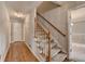Upstairs hallway with a staircase, wood floors, neutral paint, and an open doorway into a carpeted room at 1592 Walkway Ct, Lilburn, GA 30047