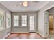 Sun room has wood flooring, view to hall and multiple windows at 1592 Walkway Ct, Lilburn, GA 30047