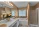 Bathroom featuring dual sinks, a large tub, and a glass shower at 4969 Truitt Ln, Decatur, GA 30035
