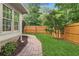 A well-manicured backyard with a stone path leading through lush greenery and a privacy fence at 100 Parkerwood Way, Alpharetta, GA 30022