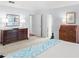 Spacious bedroom with carpet and neutral walls, featuring two dressers and a light blue accent quilt at 100 Parkerwood Way, Alpharetta, GA 30022