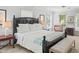 Bright bedroom with a dark wooden bed frame, many windows and a cute sitting nook at 100 Parkerwood Way, Alpharetta, GA 30022