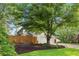 Backyard with wooden fence, well-maintained lawn, and mature trees around the house at 100 Parkerwood Way, Alpharetta, GA 30022