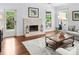 Relaxing living room featuring a fireplace, hardwood floors, neutral tones and ample natural light at 100 Parkerwood Way, Alpharetta, GA 30022