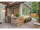 Outdoor kitchen area featuring a built-in grill, stone accents, and a paver patio at 100 Parkerwood Way, Alpharetta, GA 30022