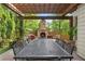 Outdoor patio with a stone fireplace, large table, and lush landscaping provides an inviting area for entertaining at 100 Parkerwood Way, Alpharetta, GA 30022