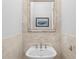 Elegant powder room with pedestal sink, decorative mirror, and travertine tile at 100 Parkerwood Way, Alpharetta, GA 30022