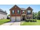 Charming two-story brick home featuring a two-car garage, well-manicured lawn, and classic architectural details at 10044 Cormac St, Jonesboro, GA 30238