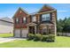 Inviting two-story brick home with a two-car garage, a well-kept lawn, and a welcoming front entrance at 10044 Cormac St, Jonesboro, GA 30238