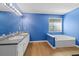 Bright bathroom features a double vanity, soaking tub, and hardwood flooring at 40 Queensland Ln, Covington, GA 30016
