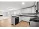 Open kitchen with views into the living room, showcasing stainless appliances and white cabinetry at 40 Queensland Ln, Covington, GA 30016