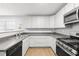 Well-lit kitchen with stainless steel appliances, grey countertops, and white cabinetry at 40 Queensland Ln, Covington, GA 30016
