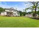 Spacious backyard featuring a covered patio, a well-maintained lawn, and a classic fence for privacy at 4395 Capstone Court, Roswell, GA 30075