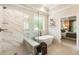 Updated bathroom featuring a glass-enclosed shower and soaking tub with brass fixtures at 4395 Capstone Court, Roswell, GA 30075