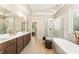 A luxurious bathroom featuring a glass-enclosed shower, soaking tub, and double vanities at 4395 Capstone Court, Roswell, GA 30075