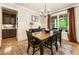 Traditional dining room with rich hardwood flooring, large window, wainscoting, and chandelier at 4395 Capstone Court, Roswell, GA 30075