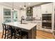 This modern kitchen has white cabinets, an island with seating, and stainless steel appliances at 4395 Capstone Court, Roswell, GA 30075