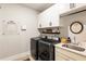 A well-organized laundry room with washer, dryer, sink, storage cabinets, and shelving at 4395 Capstone Court, Roswell, GA 30075