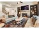 Living room featuring a brick fireplace, built-in shelving, large television, and hardwood floors at 4395 Capstone Court, Roswell, GA 30075