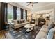 Open-concept living room with dark drapery, ceiling fan, and view of the kitchen at 4395 Capstone Court, Roswell, GA 30075