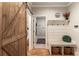 A mudroom with a wooden barn door, coat rack with bench, and built-in storage at 4395 Capstone Court, Roswell, GA 30075