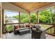Inviting covered patio featuring cozy outdoor seating, a ceiling fan, and a serene backyard view at 4395 Capstone Court, Roswell, GA 30075