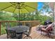 Outdoor wooden deck featuring dining set with umbrella and cozy seating area surrounded by lush greenery at 17 Sassafras Ne Trl, Cartersville, GA 30121