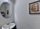 Close-up of a bathroom with a circular mirror, sink, faucet, and decorative artwork adding a touch of charm at 2639 Cooper Brook Dr, Snellville, GA 30078