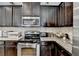 Modern kitchen with dark cabinets, granite countertops and modern stainless steel appliances at 2639 Cooper Brook Dr, Snellville, GA 30078