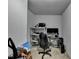 Office room with gray walls, gray carpet, dual monitor setup, shelves, and a black chair at 2639 Cooper Brook Dr, Snellville, GA 30078