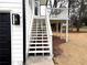 Exterior view of white stairs leading to deck, complemented by black garage door at 3663 Heatherwood Ne Dr, Marietta, GA 30066