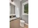 Stylish half bathroom with a modern vanity, sleek fixtures, granite countertop, and elegant decorative wall tiles at 462 Connally Se St, Atlanta, GA 30312
