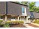 Inviting townhome exterior featuring a brick facade and a well-maintained lawn with attractive landscaping at 5170 Chemin De Vie Ne, Sandy Springs, GA 30342