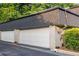 A two car brick garage featuring white doors and black roof, situated in a green surrounding at 5170 Chemin De Vie Ne, Sandy Springs, GA 30342