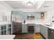 Stylish kitchen featuring stainless steel appliances, chic blue cabinetry and gorgeous hardwood flooring at 5170 Chemin De Vie Ne, Sandy Springs, GA 30342