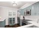 Modern kitchen boasting stainless steel appliances, stylish blue cabinetry and beautiful hardwood floors at 5170 Chemin De Vie Ne, Sandy Springs, GA 30342