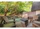 A relaxing patio featuring wooden furniture, a fire pit, and a decorative rug surrounded by greenery and a stone wall at 5170 Chemin De Vie Ne, Sandy Springs, GA 30342