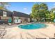 Community pool area with lounge chairs, tables, umbrellas, and clear blue swimming pool surrounded by trees at 5170 Chemin De Vie Ne, Sandy Springs, GA 30342