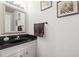 Elegant powder room with granite counters, decorative mirror, art and black fixtures at 5170 Chemin De Vie Ne, Sandy Springs, GA 30342