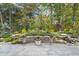 Beautiful backyard featuring a natural landscape, flower pots, and tiled patio, ideal for relaxation and outdoor enjoyment at 218 Floral Valley Dr, Woodstock, GA 30188