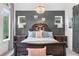 Charming bedroom with a chandelier, lamps, and accent wall with decor at 218 Floral Valley Dr, Woodstock, GA 30188
