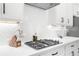 Modern kitchen features sleek white cabinetry, stainless steel appliances, and a gas cooktop at 218 Floral Valley Dr, Woodstock, GA 30188
