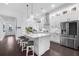 Bright, open kitchen with large island, pendant lighting, stainless steel appliances, and hardwood floors at 218 Floral Valley Dr, Woodstock, GA 30188