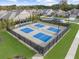 Aerial view of the community pickleball courts with lighting and lush landscaping, offering residents an active lifestyle at 218 Floral Valley Dr, Woodstock, GA 30188