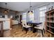 Open-concept dining area features wood floors, a modern table and chairs, and ample space for entertaining at 2763 Nautical Way, Villa Rica, GA 30180