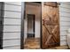 Hallway featuring a large wood sliding barn door, shiplap walls, and stylish flooring at 2763 Nautical Way, Villa Rica, GA 30180