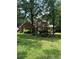 Two-story brick home with lush green lawn and mature trees, offering shade and curb appeal at 50 Ranger Se Rd, Cartersville, GA 30121