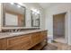 Vanity featuring double sinks, granite countertops, and a framed mirror at 901 Abernathy Ne Rd # 3020, Atlanta, GA 30328