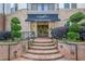 Inviting entrance to Serrano condos with brick steps, lush landscaping, and elegant awning, showing the building's charm at 901 Abernathy Ne Rd # 3020, Atlanta, GA 30328
