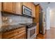 Kitchen with stainless steel oven, microwave, and refrigerator; granite counters, tile backsplash, wooden cabinets, and hardwood floors at 901 Abernathy Ne Rd # 3020, Atlanta, GA 30328
